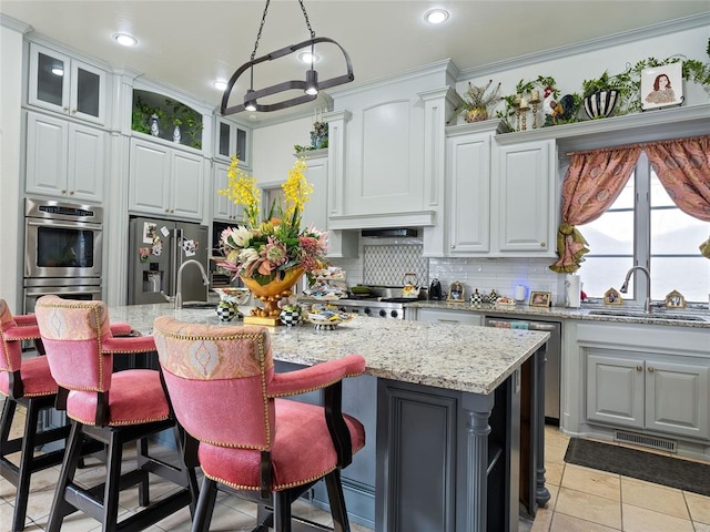 5808 Mistletoe Ct, Oklahoma City, OK 73142 - kitchen featuring sink, stainless steel appliances, tasteful backsplash, and an island with sink