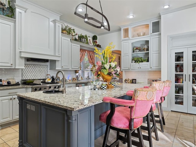 5808 Mistletoe Ct, Oklahoma City, OK 73142 - kitchen with light stone countertops, a kitchen island with sink, light tile patterned flooring, and pendant lighting