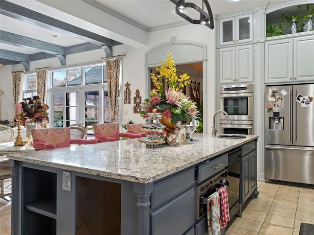 5808 Mistletoe Ct, Oklahoma City, OK 73142 - kitchen featuring a kitchen island with sink, sink, appliances with stainless steel finishes, beam ceiling, and white cabinetry