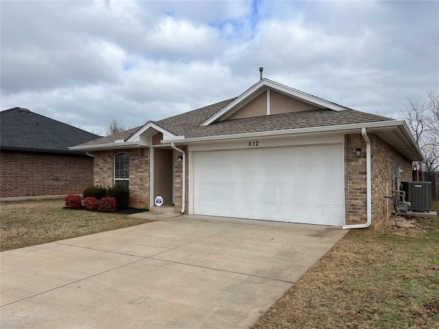 ranch-style house with central air condition unit and a garage