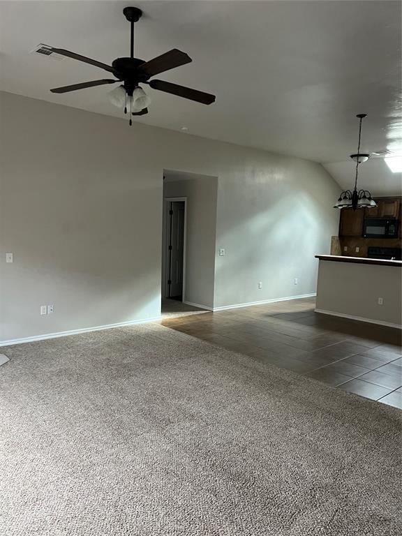 unfurnished living room featuring tile patterned floors, ceiling fan, and vaulted ceiling