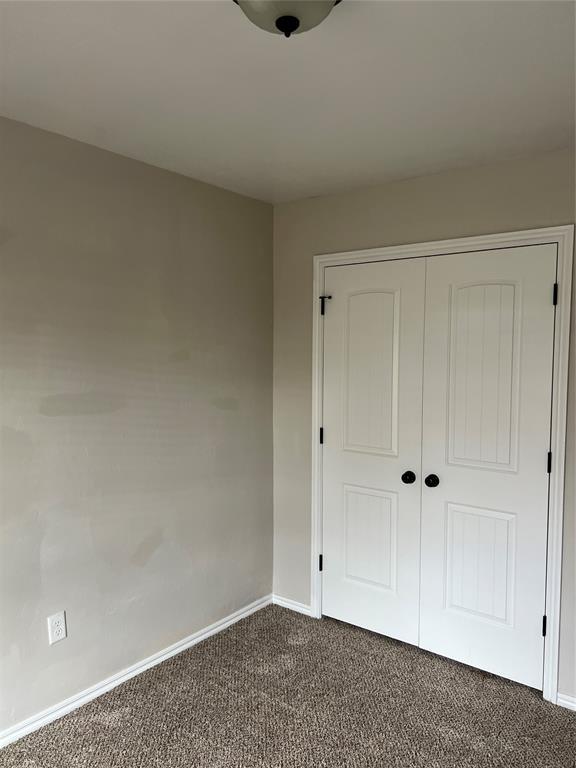 unfurnished bedroom with a closet and carpet floors