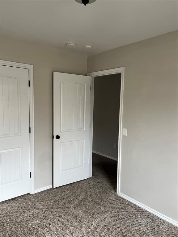 unfurnished bedroom with dark carpet