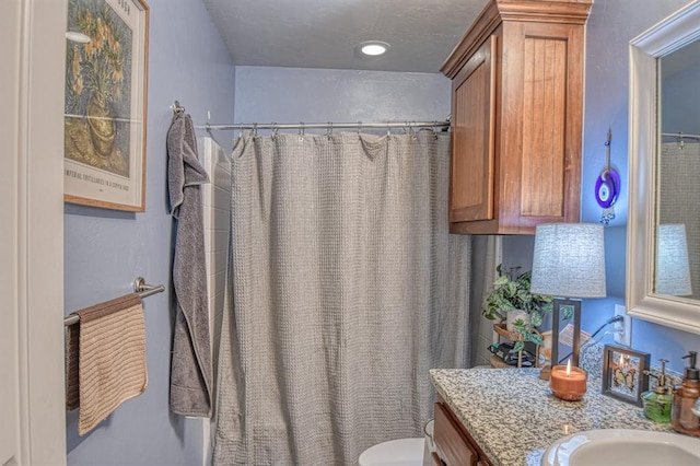 bathroom with vanity, toilet, and curtained shower