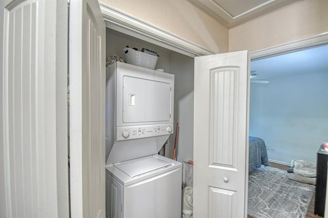 laundry area featuring hardwood / wood-style flooring and stacked washer / dryer