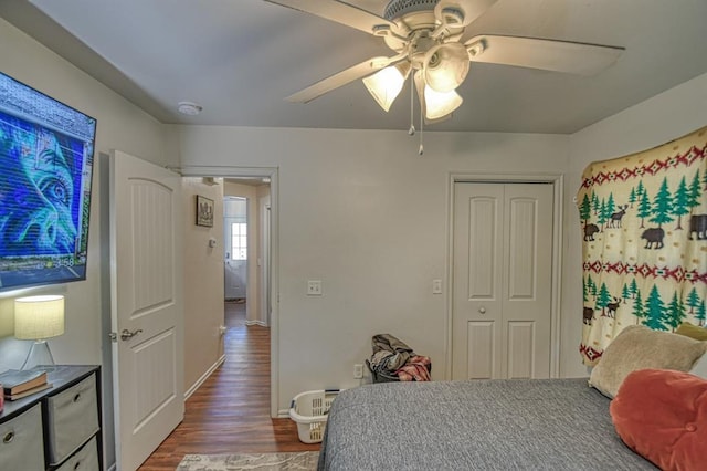 bedroom featuring ceiling fan, dark hardwood / wood-style flooring, and a closet