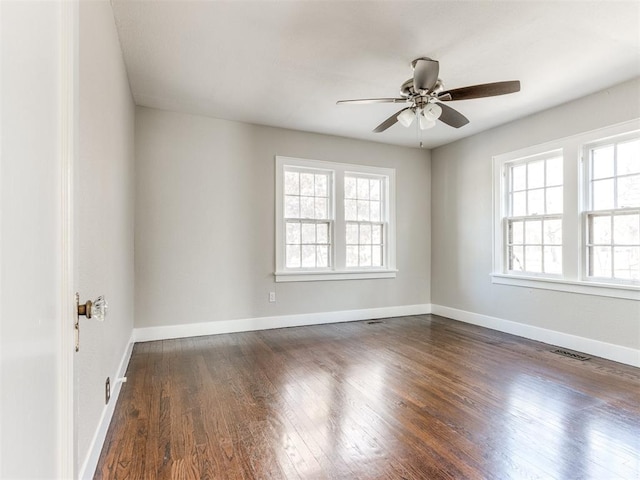 spare room with ceiling fan, a healthy amount of sunlight, and dark hardwood / wood-style flooring