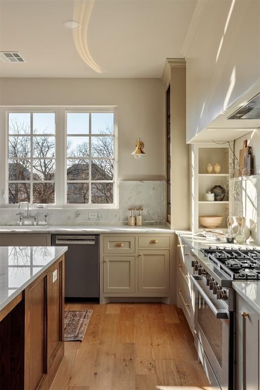 kitchen with ventilation hood, plenty of natural light, stainless steel appliances, and light hardwood / wood-style flooring