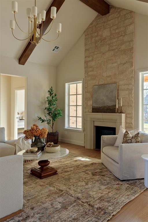 living room with a fireplace, hardwood / wood-style floors, high vaulted ceiling, and beam ceiling