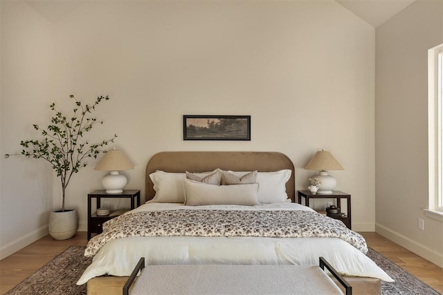 bedroom with lofted ceiling and wood-type flooring