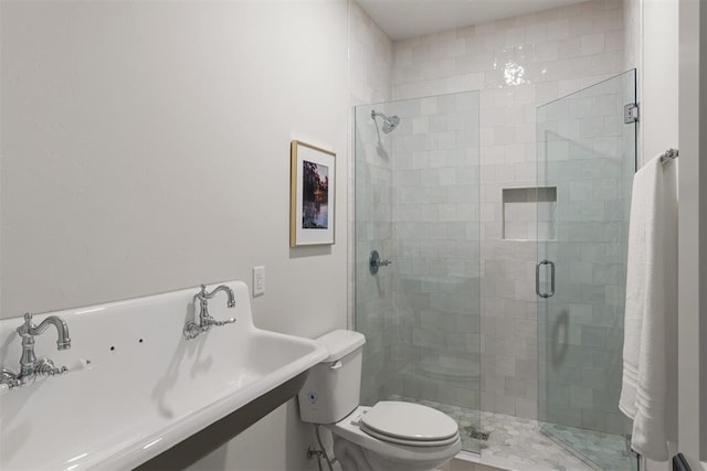 bathroom with toilet, a shower with shower door, and sink