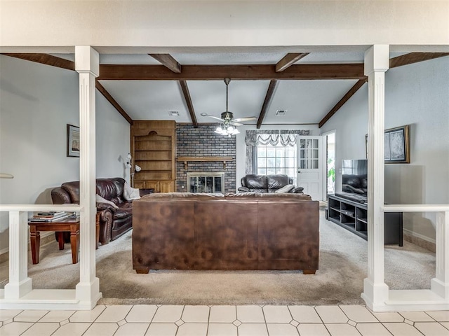 living room featuring vaulted ceiling with beams, ceiling fan, a fireplace, and ornate columns