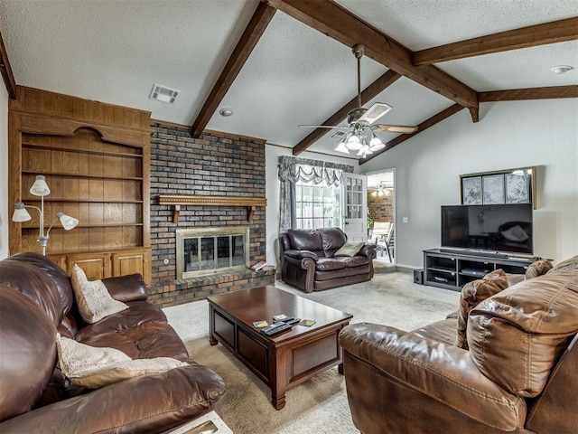 carpeted living room with a textured ceiling, lofted ceiling with beams, a brick fireplace, and ceiling fan