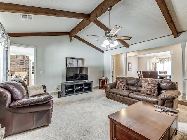 carpeted living room featuring ceiling fan with notable chandelier and vaulted ceiling with beams