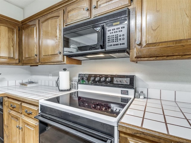 kitchen featuring tile countertops and black appliances