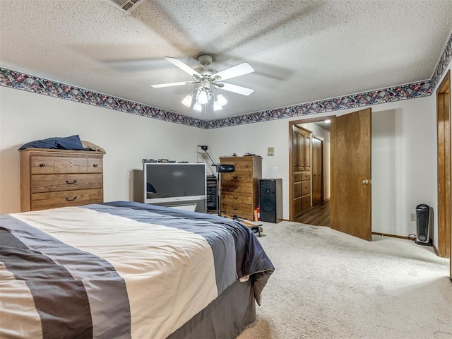 carpeted bedroom featuring a textured ceiling and ceiling fan