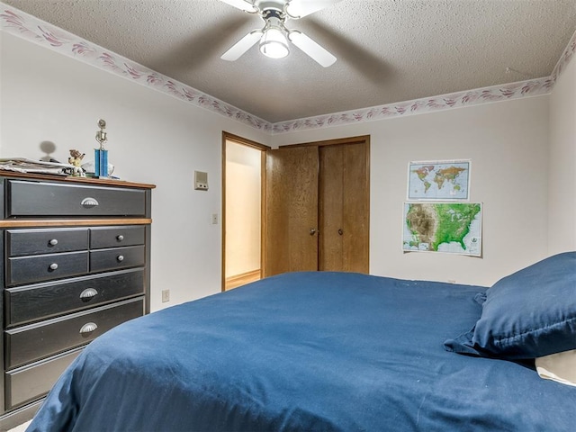 bedroom with ceiling fan, a closet, and a textured ceiling