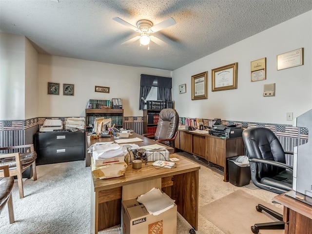 carpeted office space featuring ceiling fan and a textured ceiling