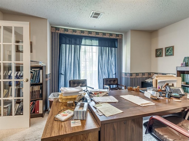 office featuring light carpet and a textured ceiling