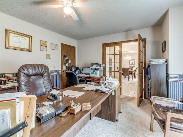 office featuring ceiling fan with notable chandelier, french doors, a textured ceiling, and light colored carpet