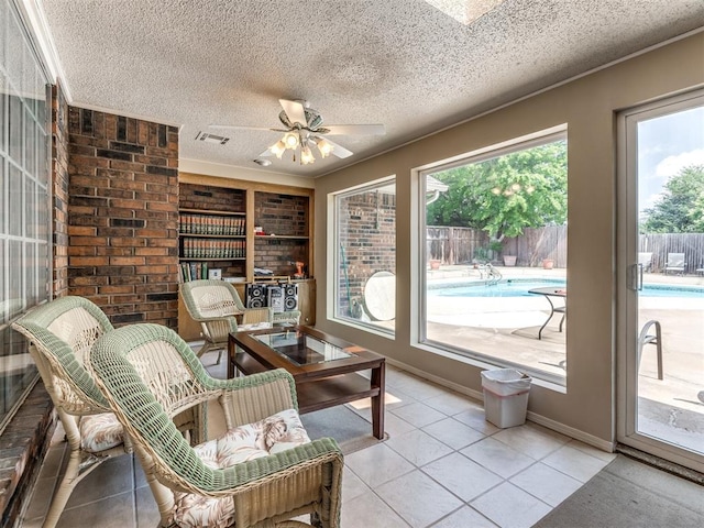 sunroom / solarium featuring ceiling fan