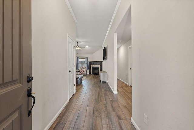 corridor with wood-type flooring and ornamental molding