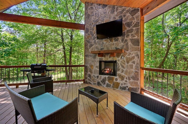 wooden deck featuring an outdoor stone fireplace