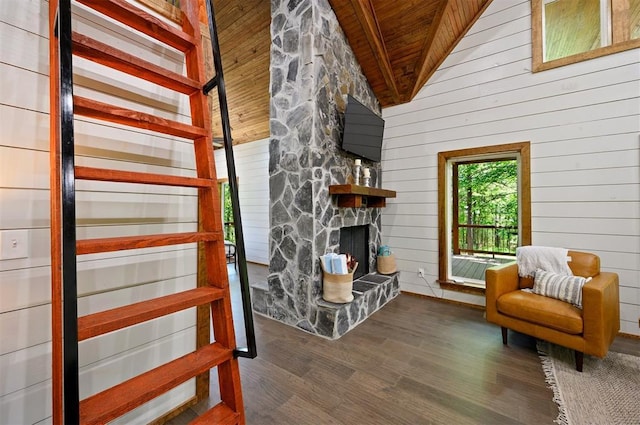 unfurnished room with wooden ceiling, beamed ceiling, dark hardwood / wood-style flooring, wooden walls, and a fireplace