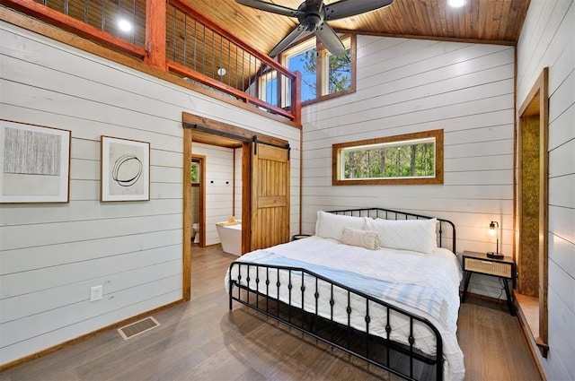 bedroom with ceiling fan, wood-type flooring, a barn door, and wood ceiling