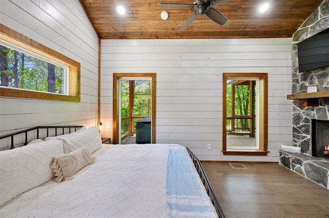 bedroom featuring dark wood-type flooring, vaulted ceiling, a fireplace, ceiling fan, and wooden ceiling