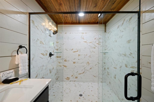 bathroom with a shower with shower door, wooden ceiling, and vanity