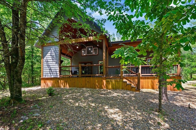 rear view of property featuring a wooden deck