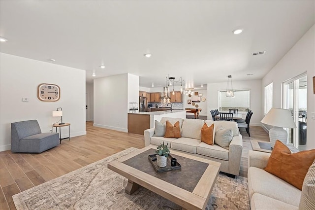 living room featuring sink and light hardwood / wood-style floors