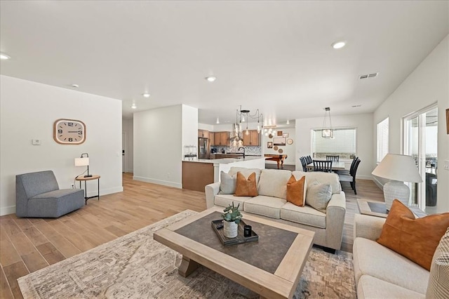 living room featuring sink and light hardwood / wood-style flooring