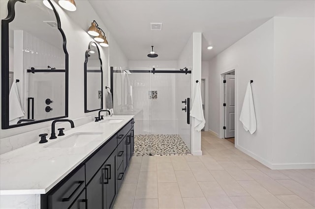 bathroom with a shower with door, vanity, and tile patterned flooring