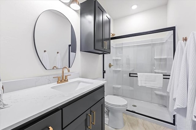 bathroom featuring vanity, an enclosed shower, and toilet