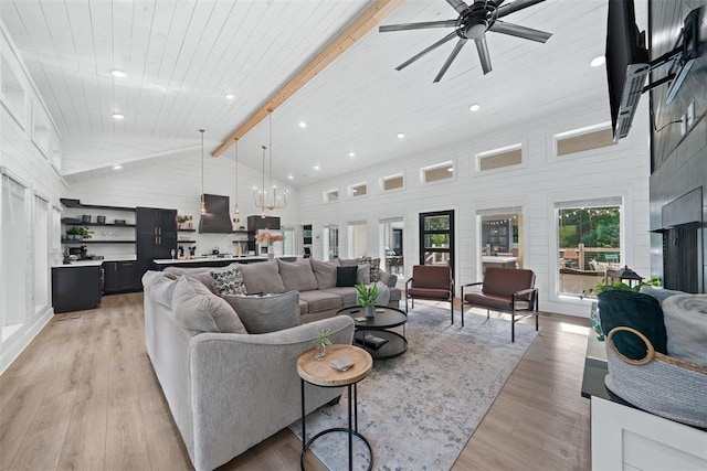 living room with ceiling fan with notable chandelier, beam ceiling, light hardwood / wood-style floors, and high vaulted ceiling