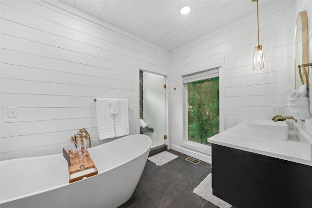 bathroom with wooden walls, a bathtub, and vanity