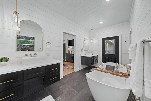 bathroom with a tub to relax in, wood walls, and vanity