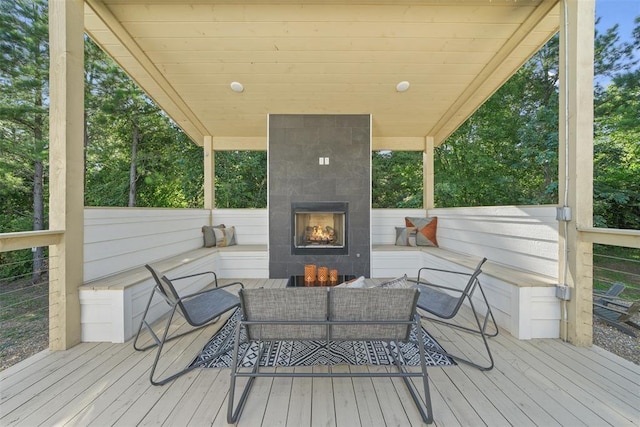 wooden terrace featuring an outdoor living space with a fireplace