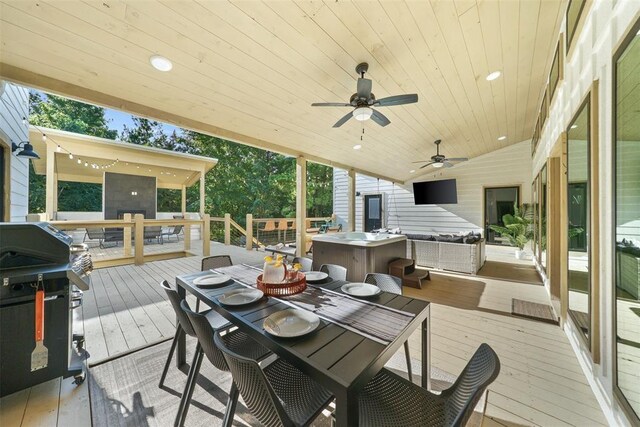 wooden deck with outdoor lounge area, ceiling fan, and a grill