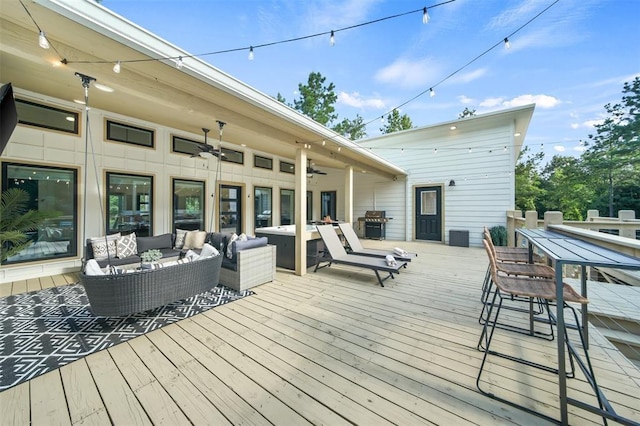 deck with area for grilling, ceiling fan, and an outdoor hangout area