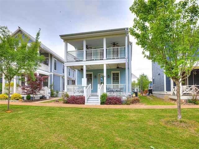 view of front of home featuring a balcony, covered porch, ceiling fan, and a front yard