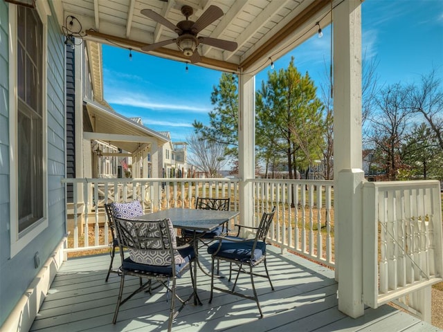 wooden deck with a ceiling fan and outdoor dining area