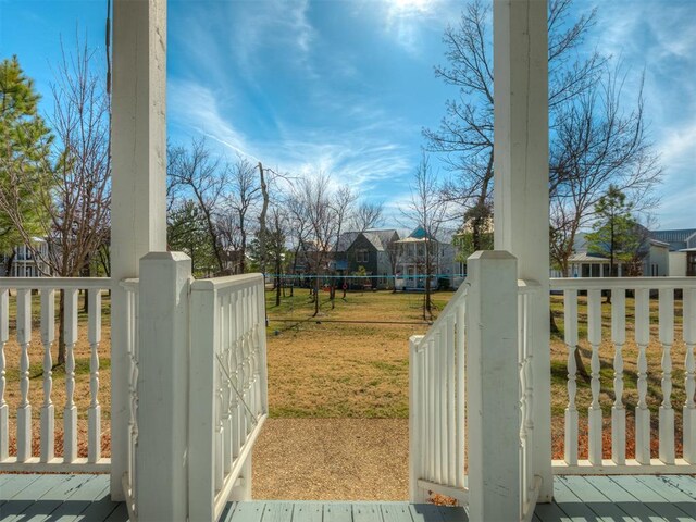 view of gate featuring a residential view, a yard, and a wooden deck