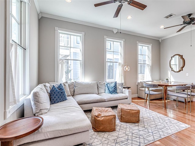 living area with recessed lighting, wood finished floors, visible vents, baseboards, and ornamental molding