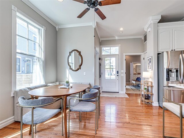 dining space featuring light wood-style floors, baseboards, visible vents, and ornamental molding