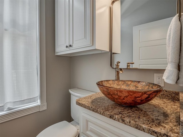 half bath featuring toilet and vanity