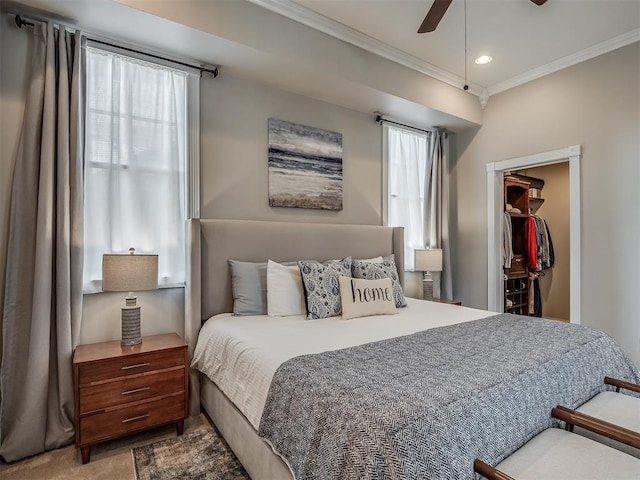 carpeted bedroom with ceiling fan, recessed lighting, a closet, a walk in closet, and crown molding