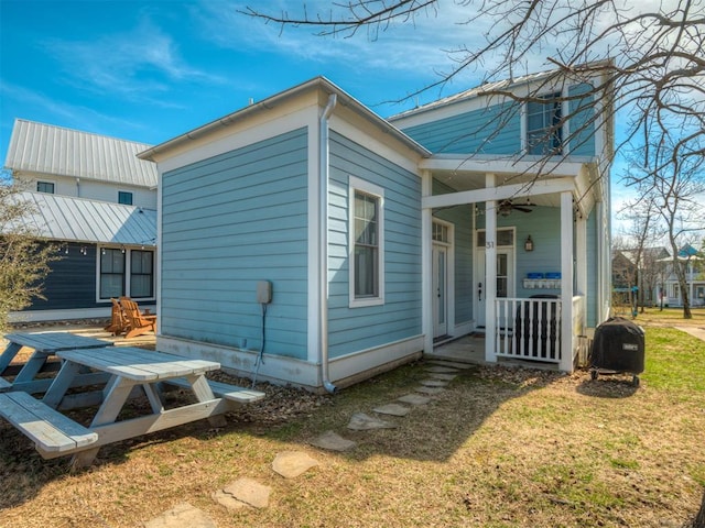 view of home's exterior featuring ceiling fan and a yard